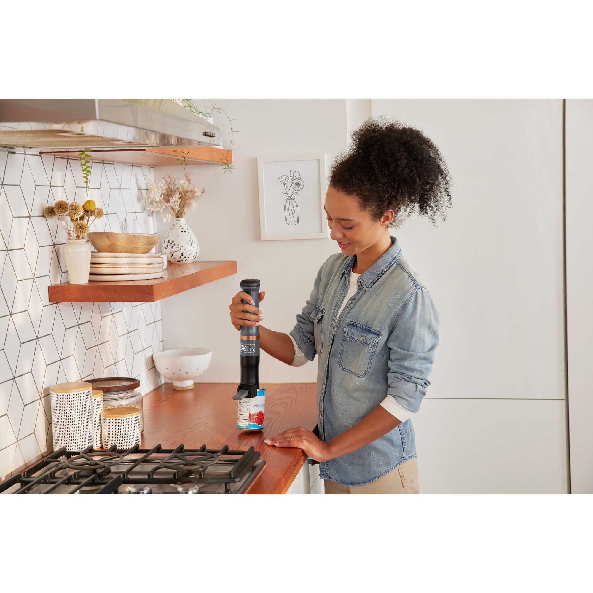 A person discards a lid with the BLACK+DECKER kitchen wand™ Can Opener Attachment. Easy lid removal.