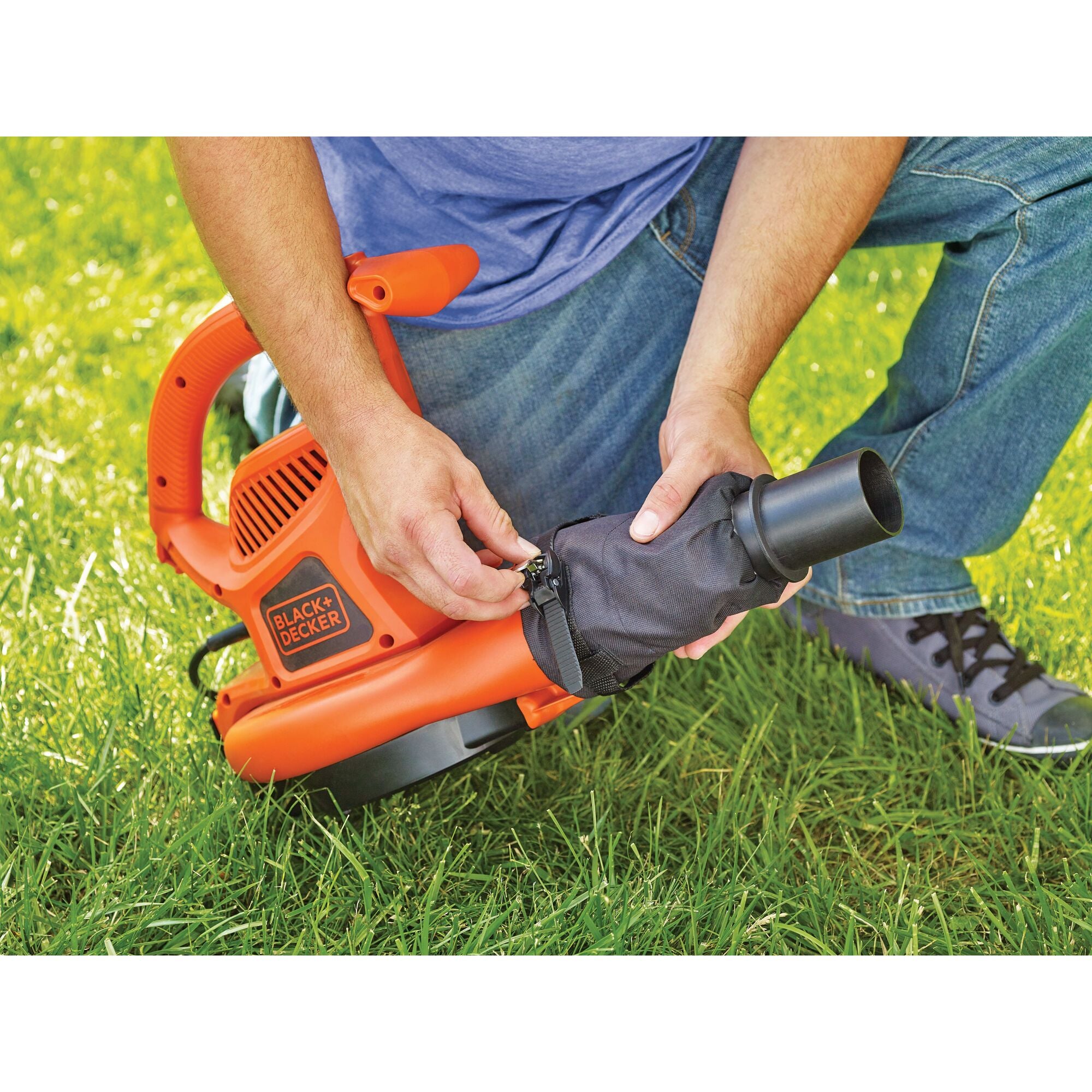 A man is detaching the pipe of the BLACK+DECKER Gutter Clean Attachment for Blower.