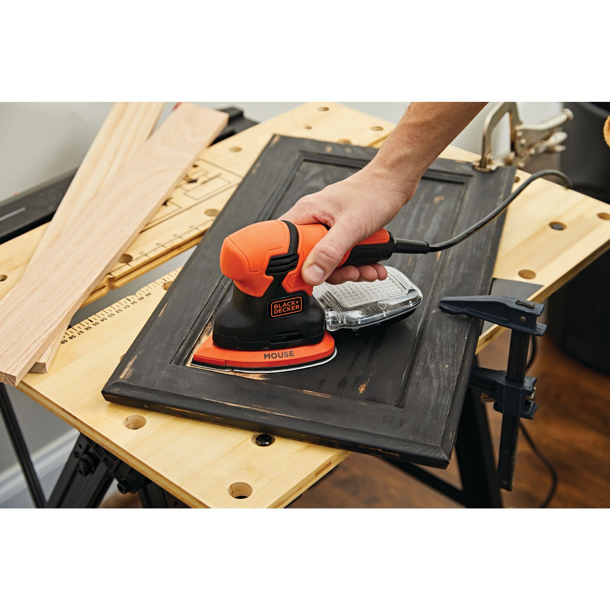 1.2 Ampere mouse sander being used by a person to sand wooden frame.