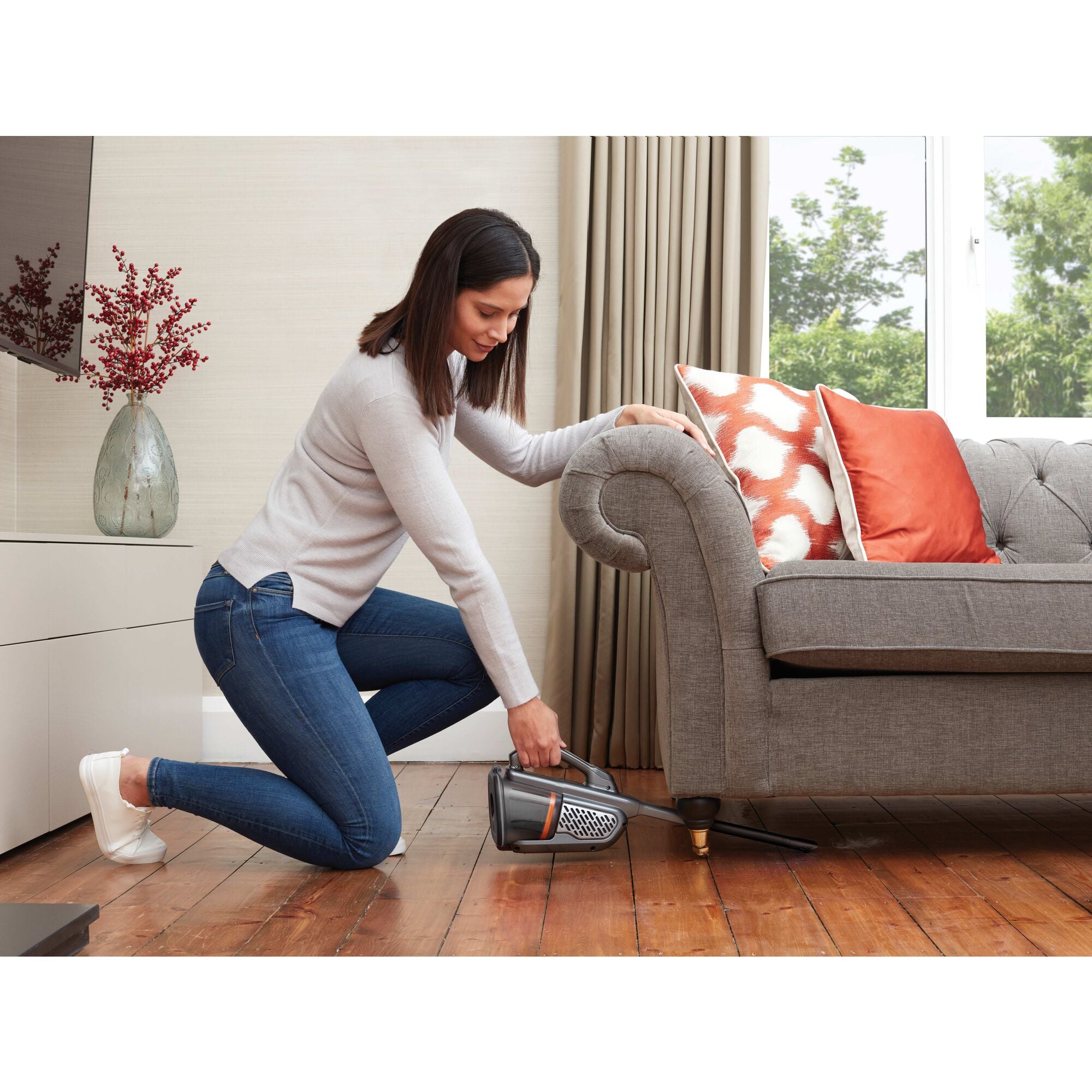 Dustbuster AdvancedClean plus Hand Vacuum being used by person to remove dirt from base of car trunk.