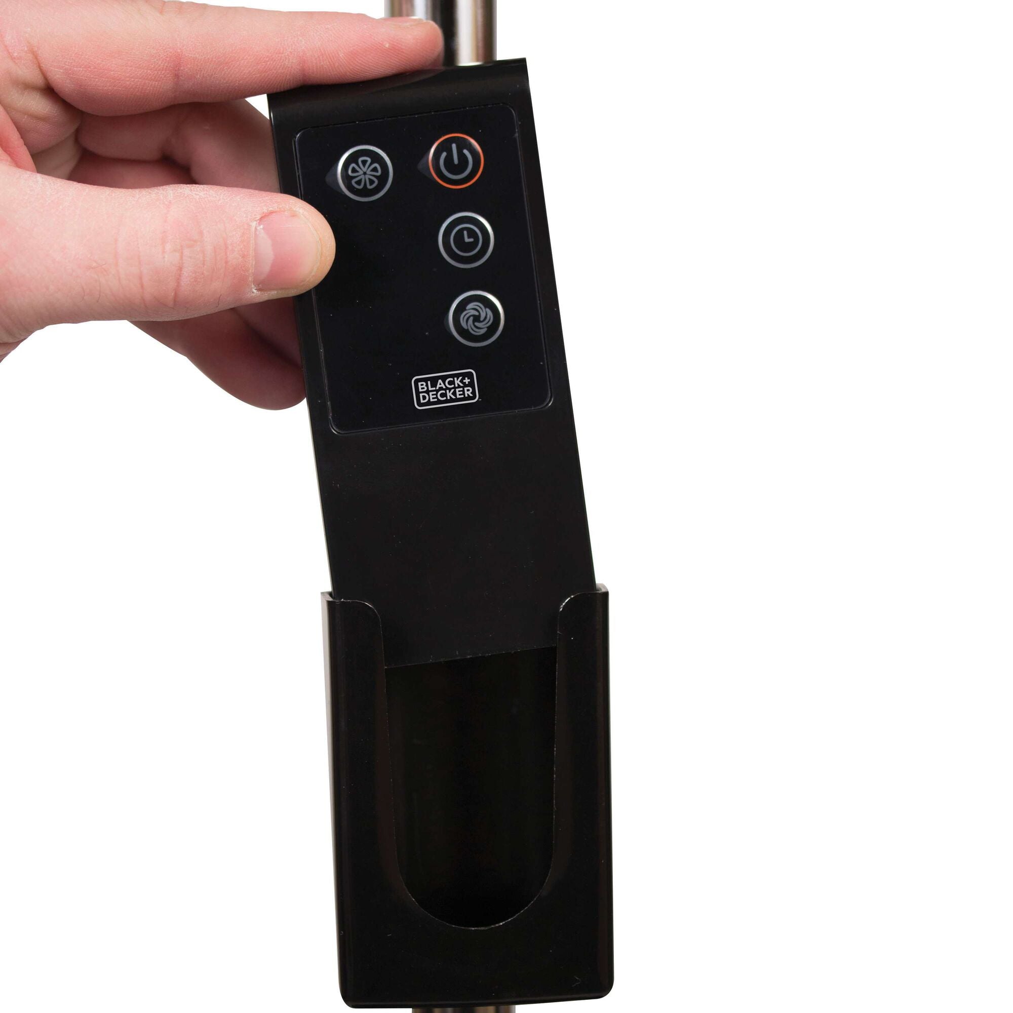 Remote being placed in on board storage for remote on 18 Inch Stand Fan.