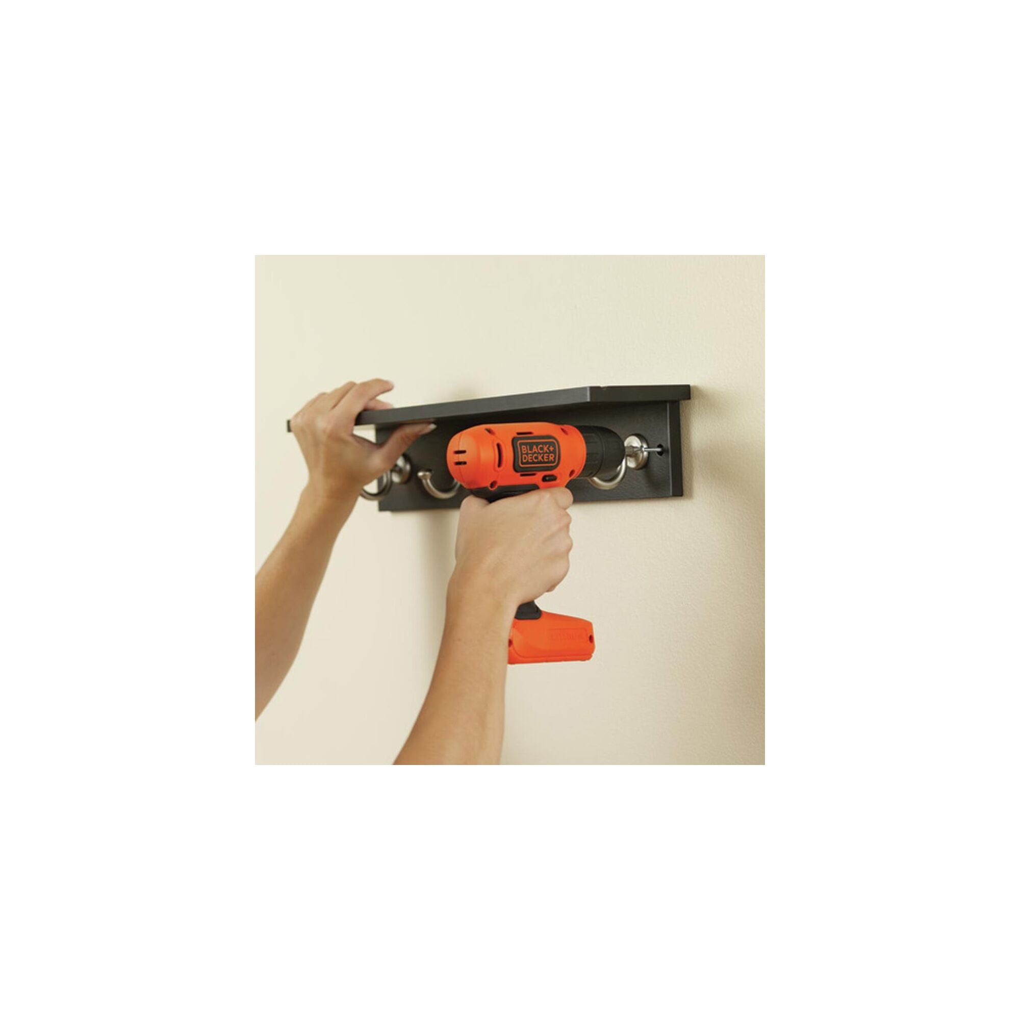 Person using Cordless Lithium Drill to put wall hooks with ease.