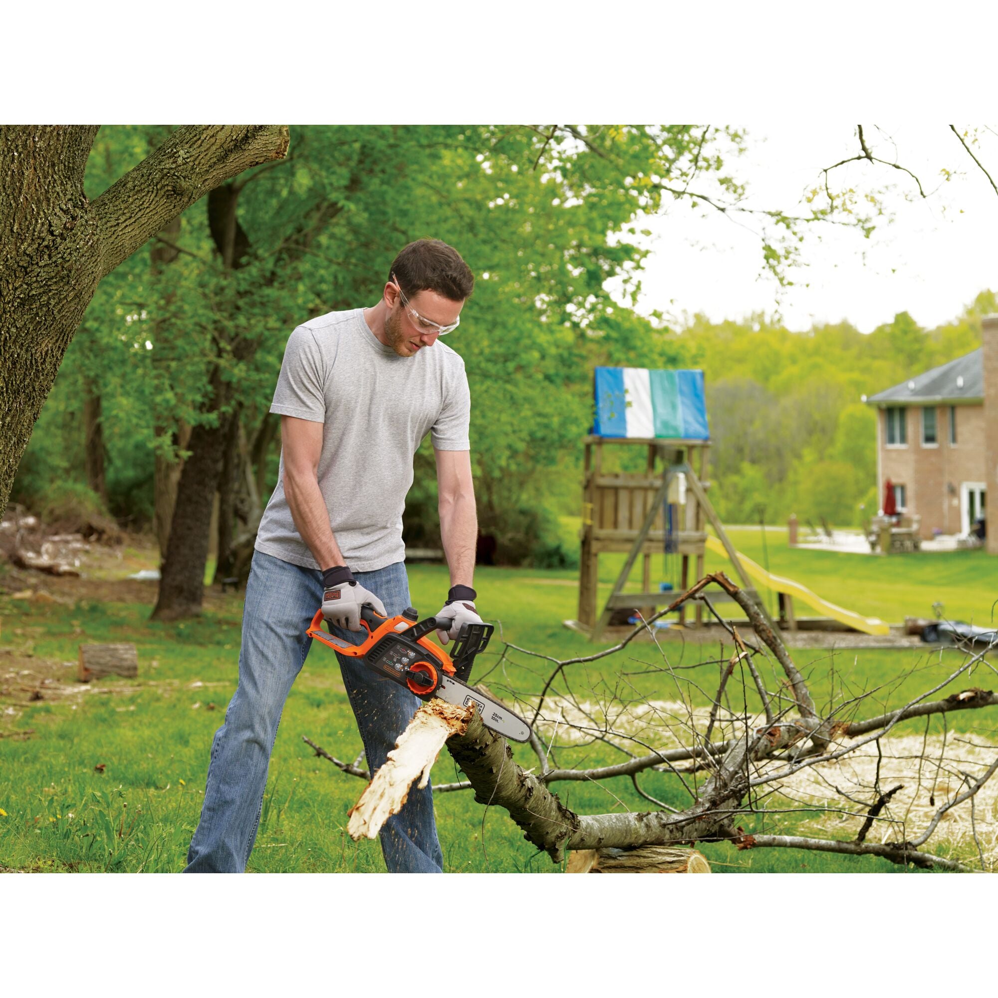 A person cuts a tree with the BLACK+DECKER 20V MAX* 10-in. Cordless Chainsaw Kit. Low-kickback bar and chain lets you easily make quick, smooth cuts.