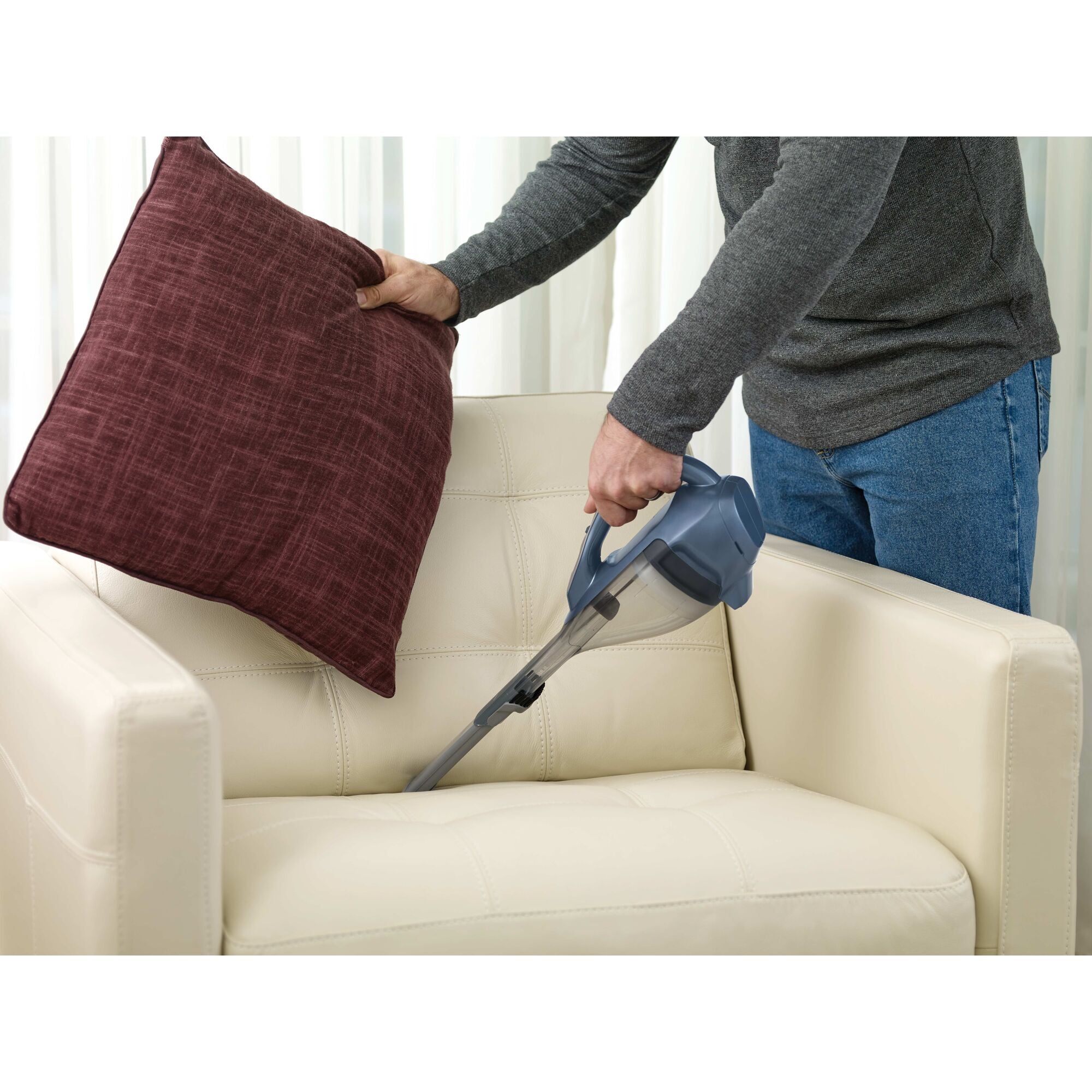 Dustbuster AdvancedClean Cordless Hand Vacuum being used to clean sofa.