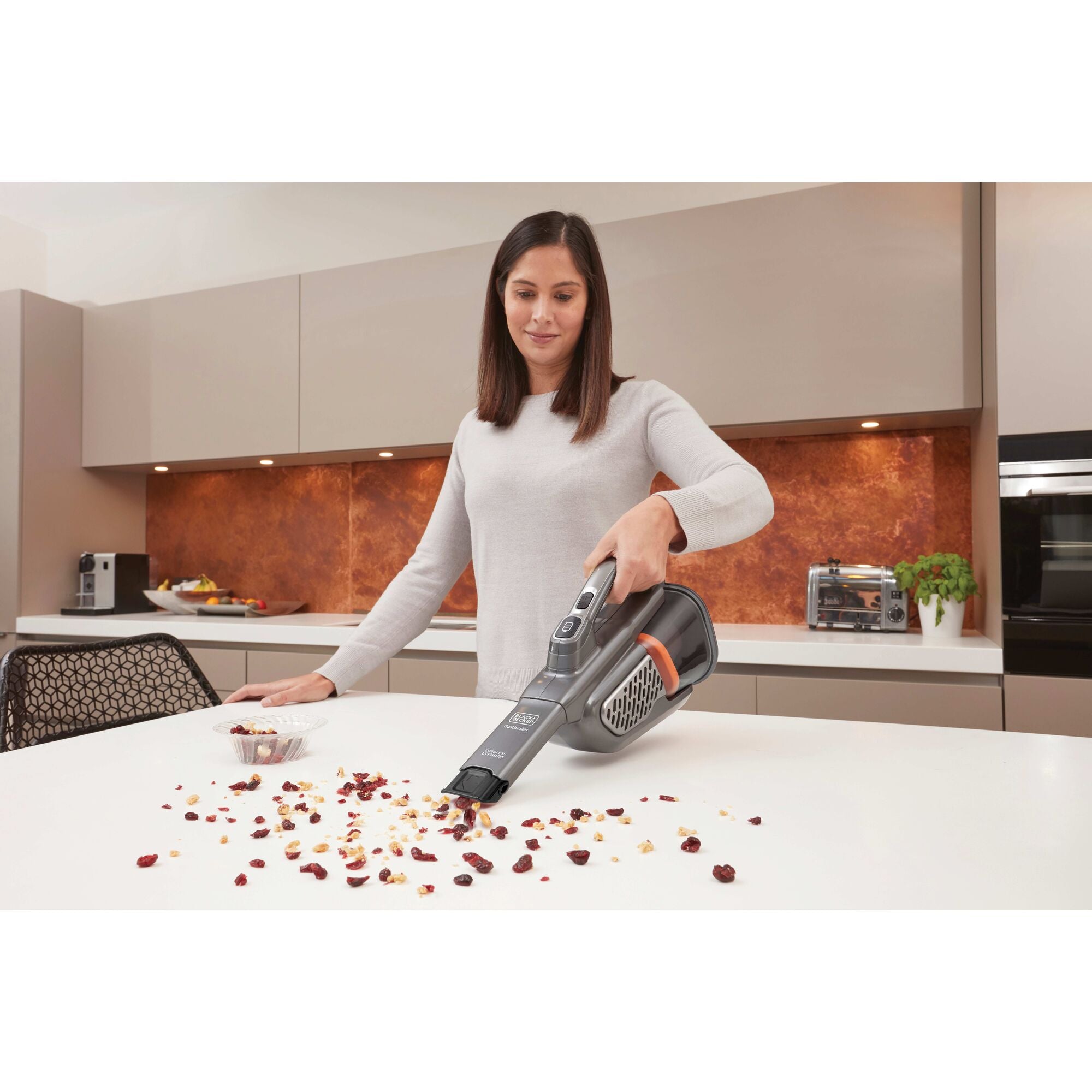 MAX Dustbuster Advanced Clean plus Hand Vacuum being used by person to clean sofa indoors.