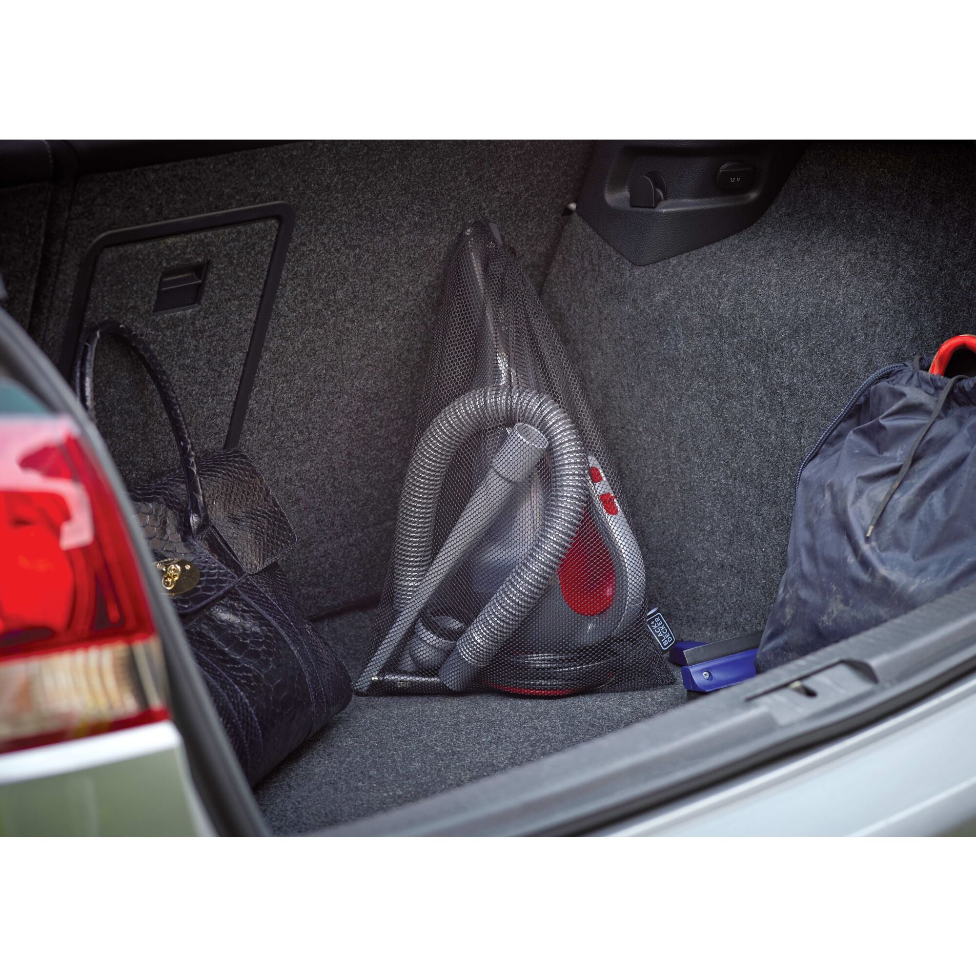 Dustbuster car handheld vacuum placed in the trunk of a car.