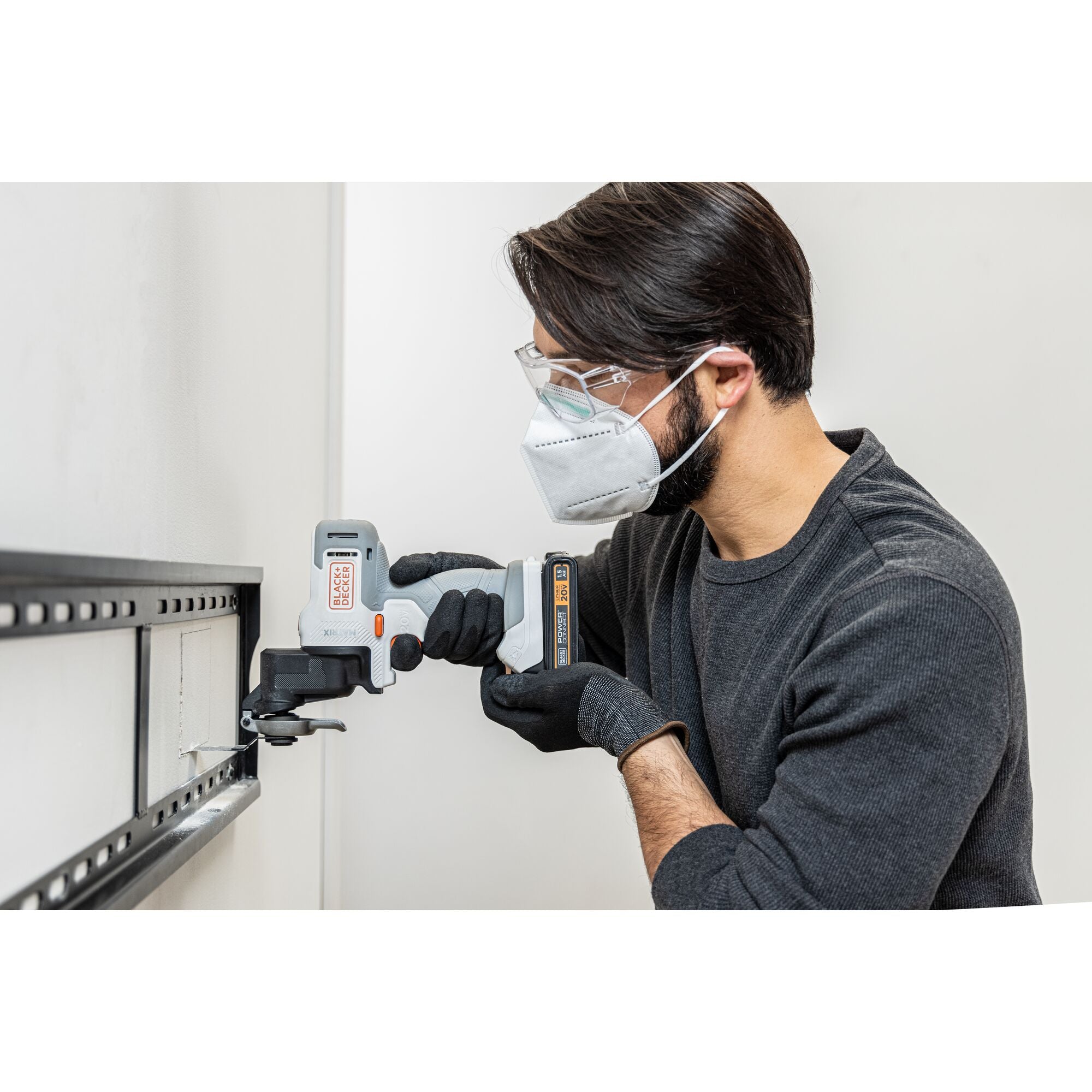 Person uses the BLACK+DECKER Multi-tool attachment to cut a hole in drywall.