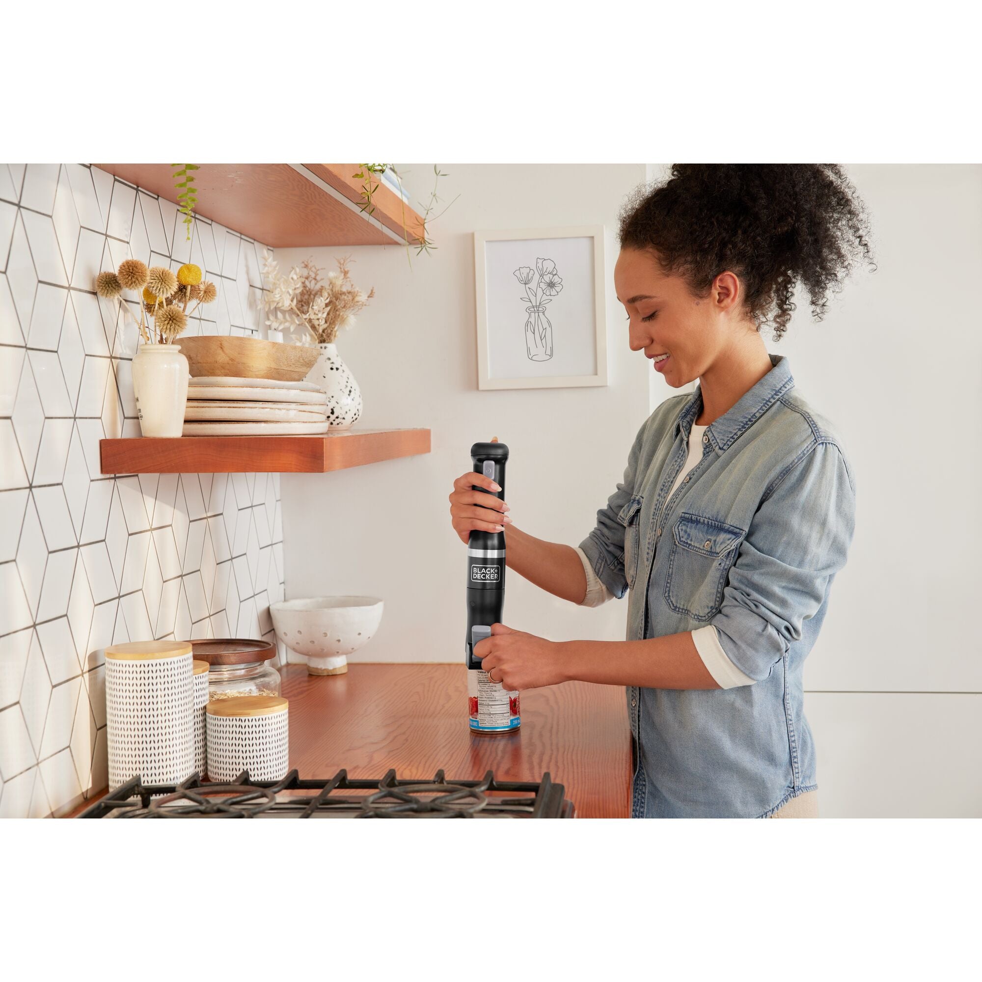 Talent using the black, BLACK+DECKER kitchen wand immersion blender to blend soup