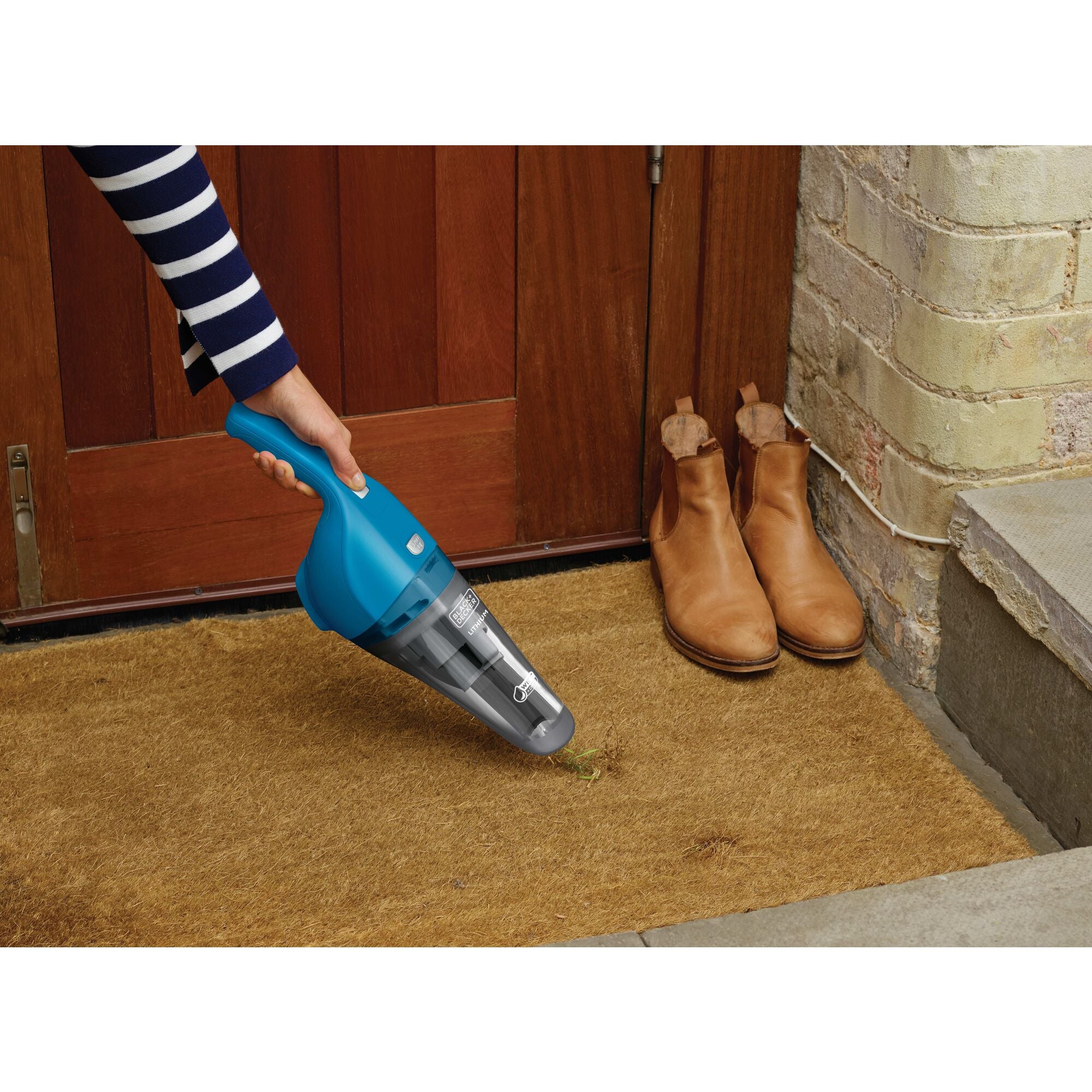 Dustbuster quickclean cordless hand vacuum wet and dry being used to vacuum mud from the doormat.