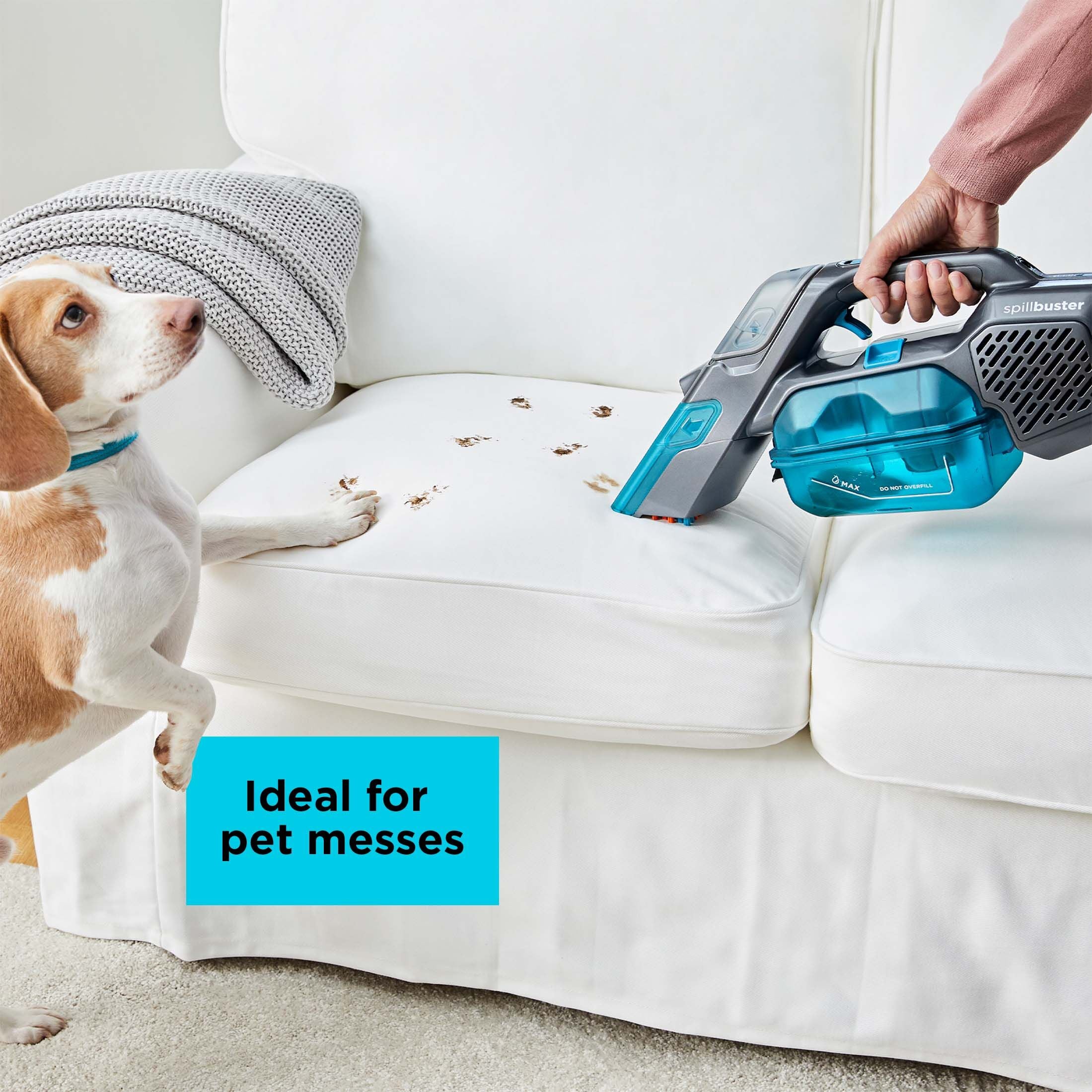 Person cleaning dirty paw prints off a white sofa with the BLACK+DECKER Spillbuster