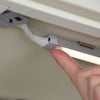 A person is pressing the button of a BLACK+DECKER 3-Bar Led Under Cabinet Lighting.