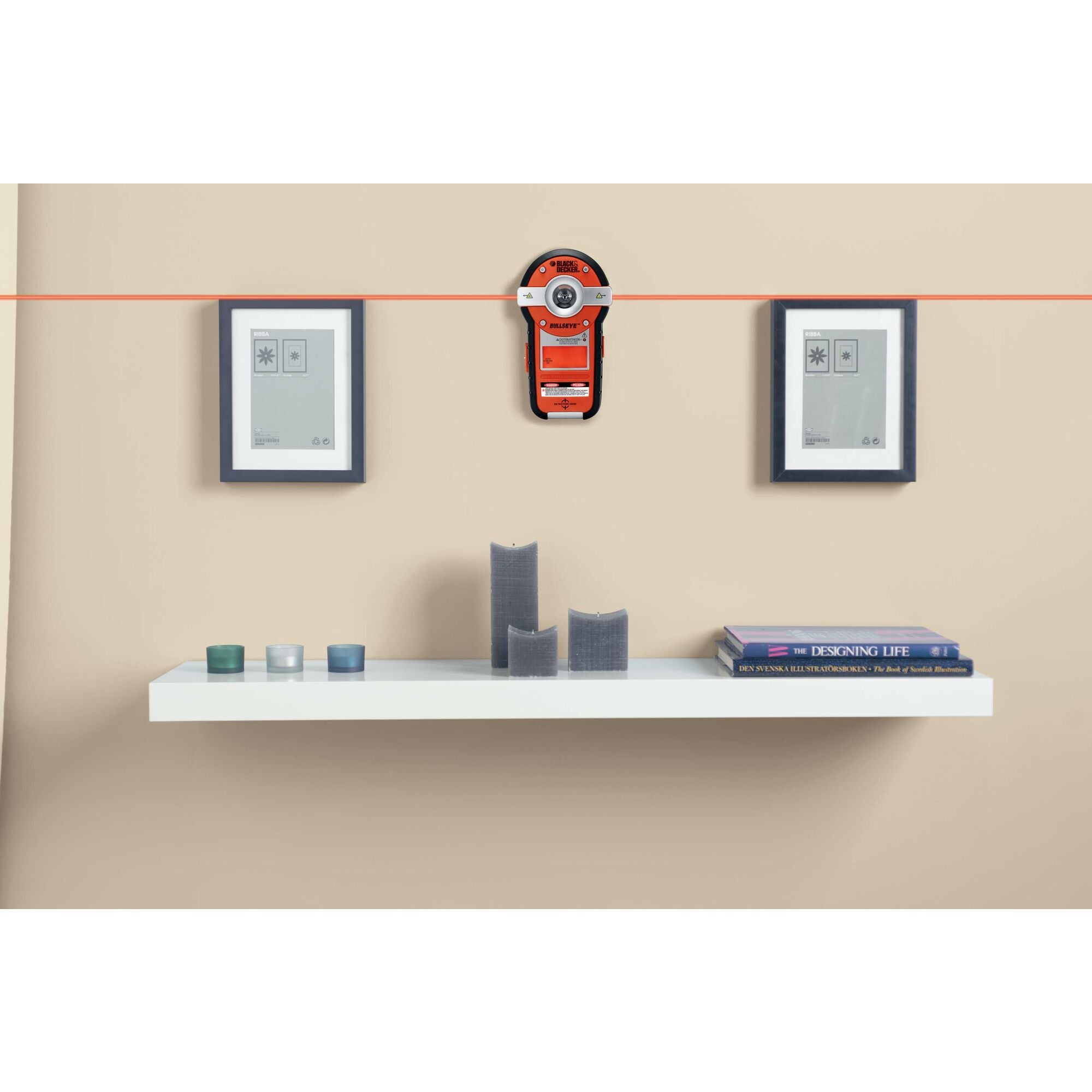 A person mounts a shelf using the BLACK+DECKER Auto-Leveling Line Laser With Stud Finder. LED screen easy to read for simple stud identification.