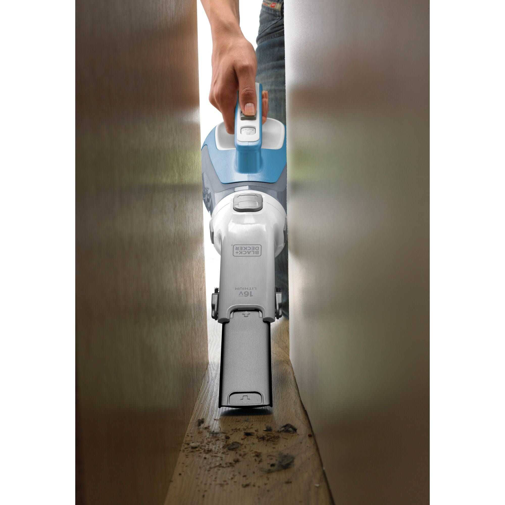 dustbuster hand vacuum being used to clean hard to reach area.