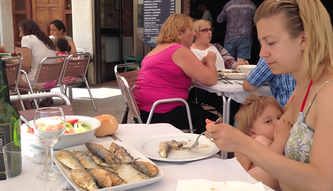 The mother breastfed her baby while eating in a restaurant