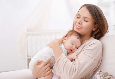 Baby sleeping in mother's arms