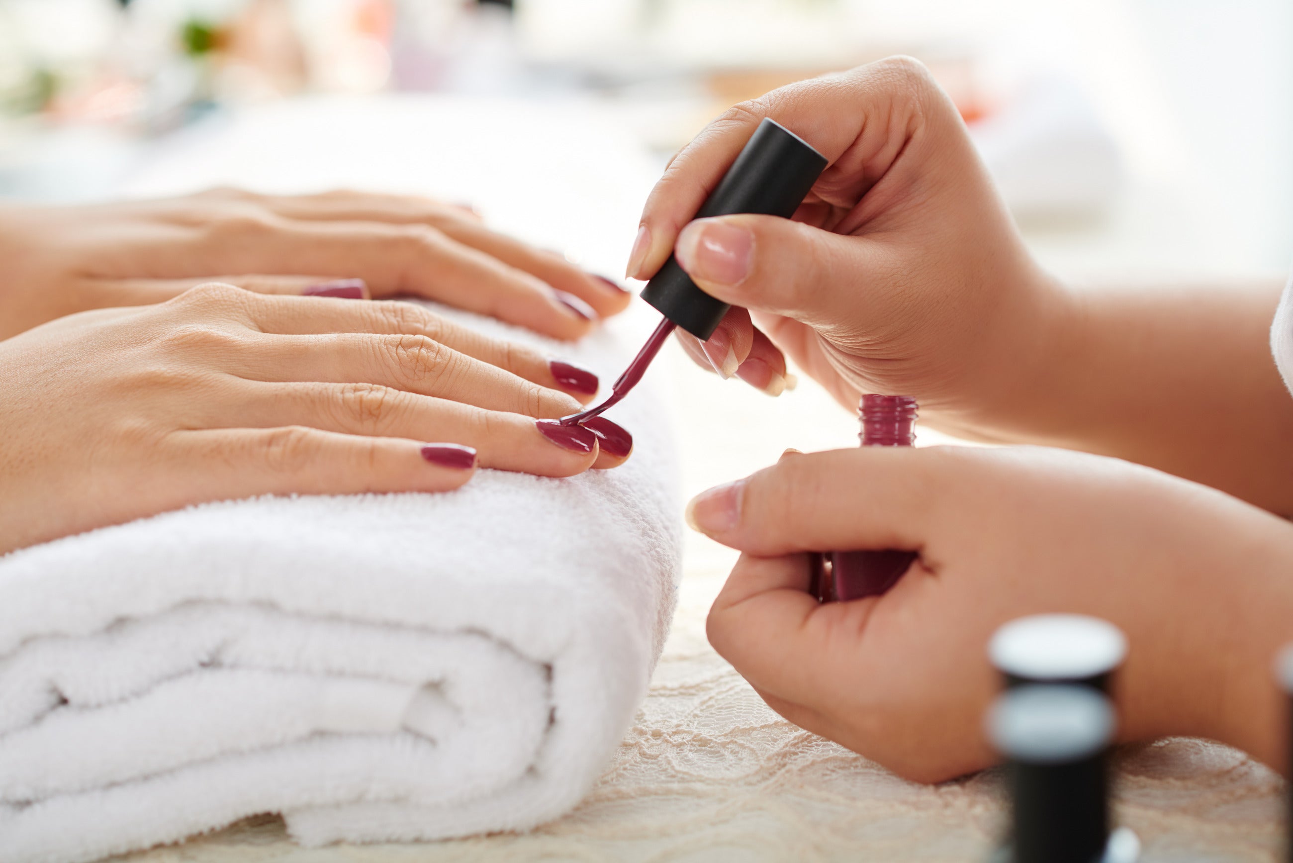 Gel nail polish being applied to a nail in a salon environment