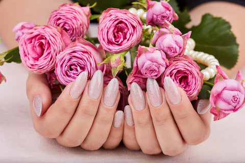 Pink nails with glitter holding a bouquet