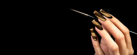 Hand with stylish nails holding a nail art brush