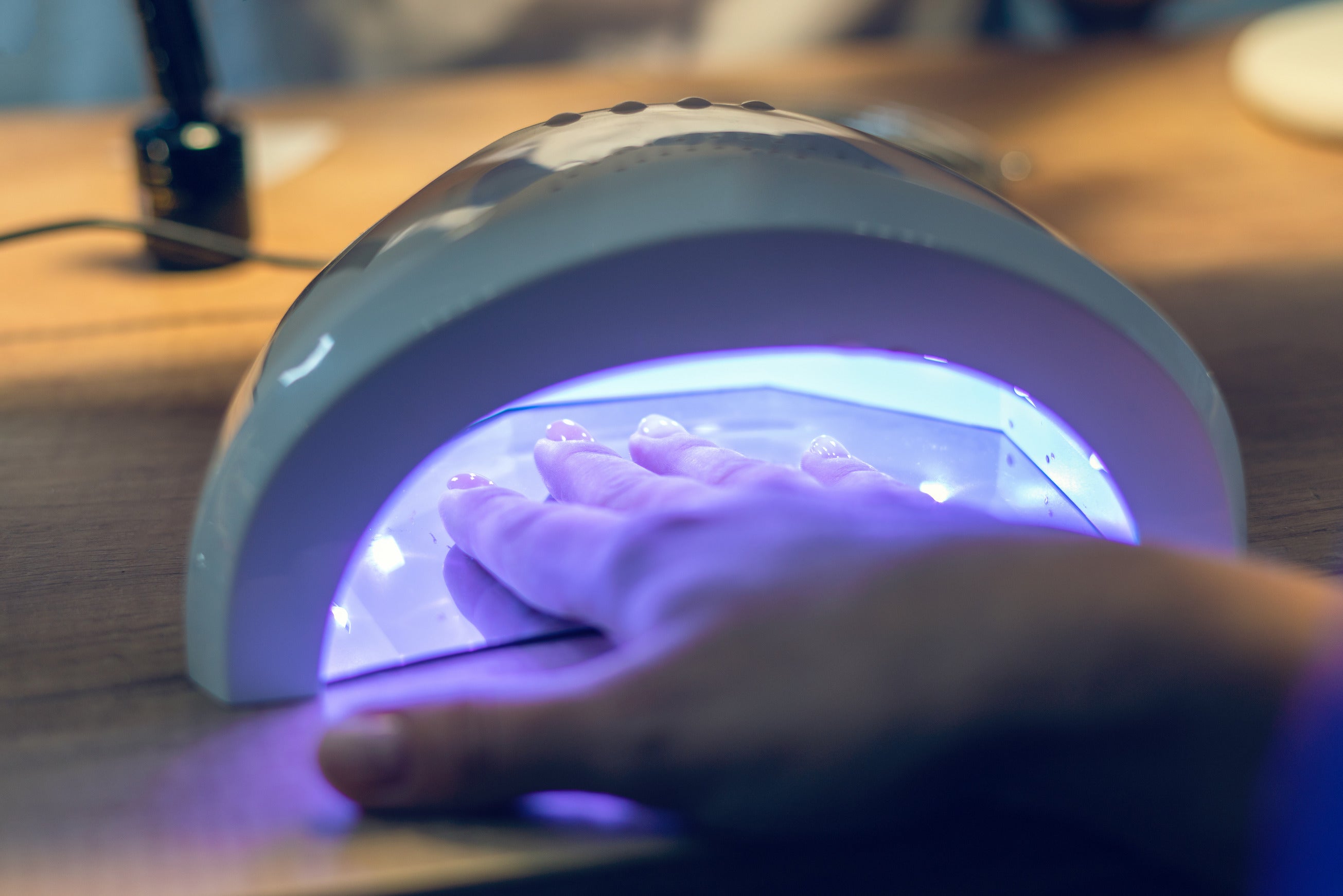 Nails being cured in a UV Lamp after gel polish has been applied