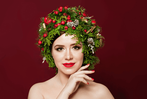 Woman with holly and berries on her head with well manicured nails.