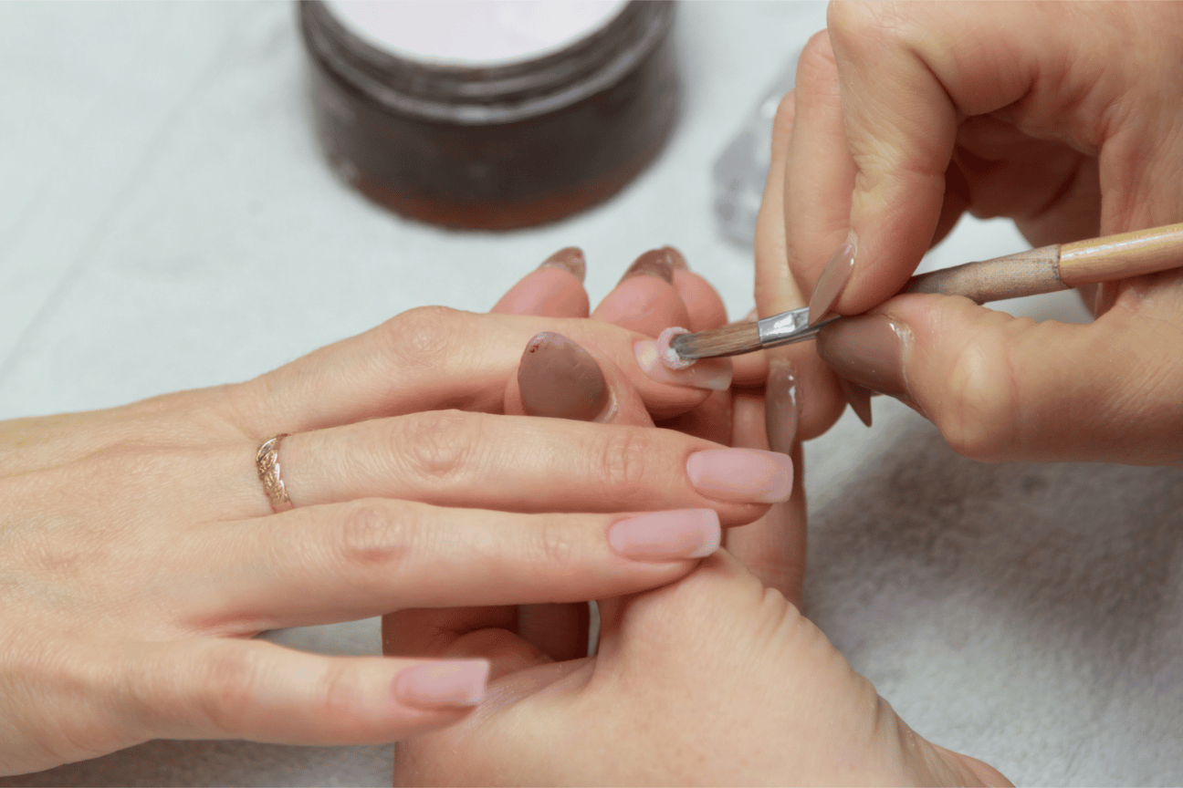 Acrylic being applied to nail during manicure
