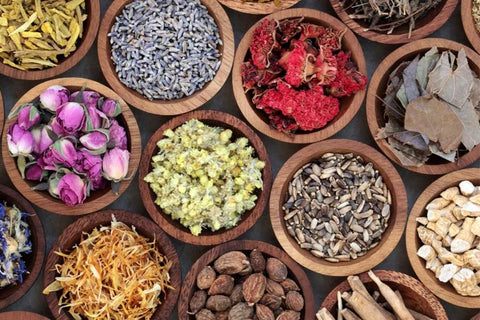 Various wood bowls filled with raw herbs