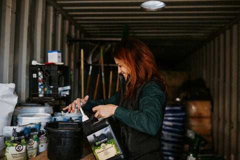 A Silver Lining Herbs employee measuring out supplements for horses
