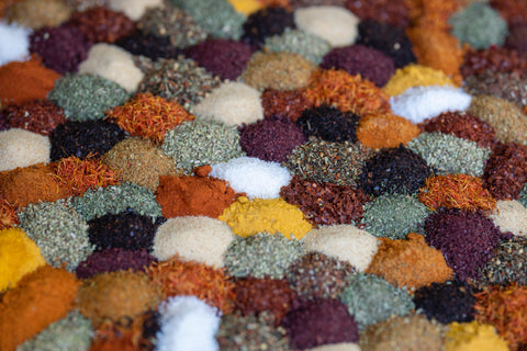 A variety of piles of different colored spices