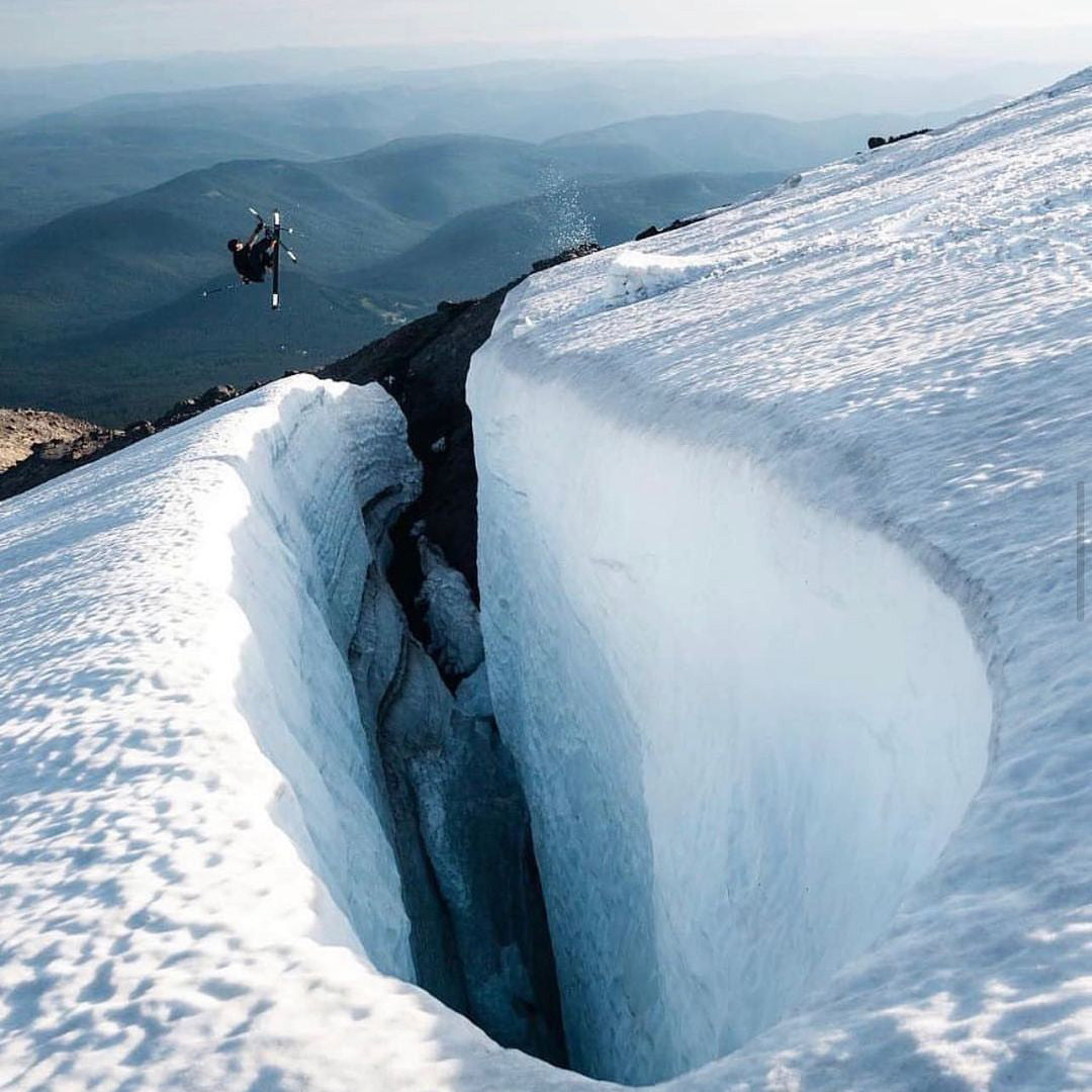 Man jumping over a crevice in his skis