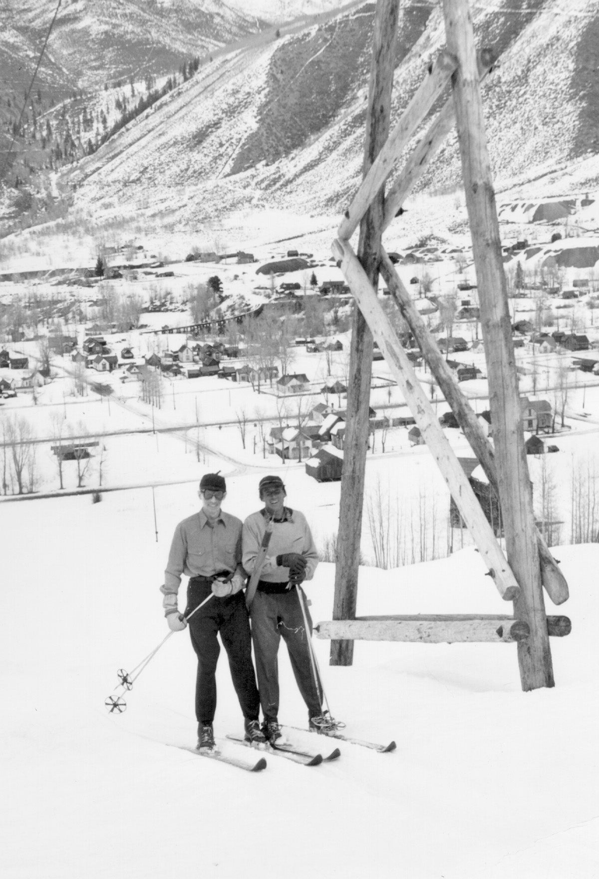 Two skiiers getting on a vintage Aspen ski lift.