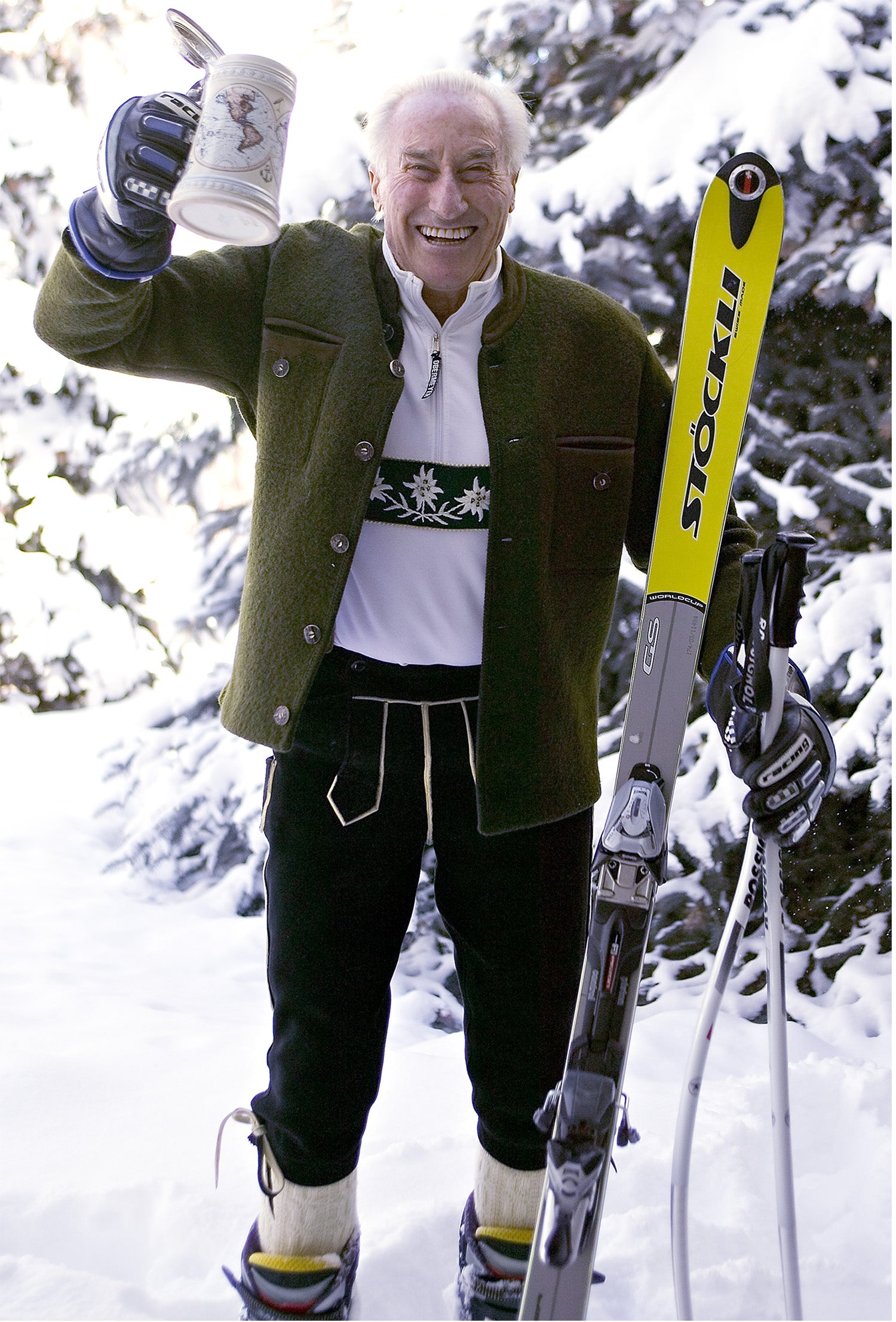 Klaus Obermeyer raising a stein in his skis and liderhosen 