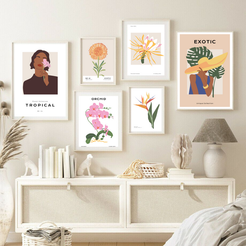 alt="floral posters with different tropical flowers and female shapes in a cozy living room"