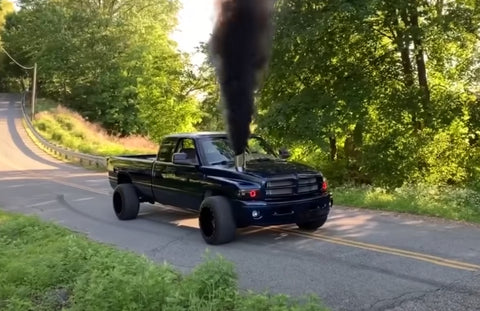 Diesel truck with performance enhancements roaring on the road.