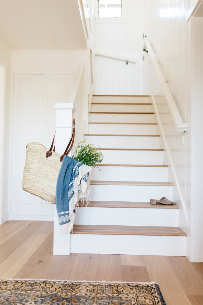 Bright white modern California Coastal retreat entryway stairs with white risers by greige design shop + interiors in Laguna Beach, Ca.