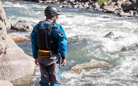 Scouting a whitewater rapid with a River Station hip throw bag.