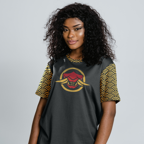 Black woman with black coily hair in an Oni Threads Streetwear Seigiaha All Over Print T Shirt. She is smiling back at the camera casually with a slightly leaned pose.