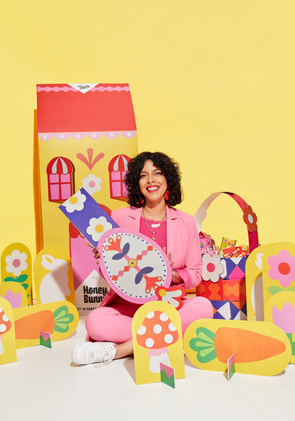 Kitiya Palaskas in collaboration with Hey Tiger Chocolate, sitting with and surrounded by giant paper props for Easter collaboration