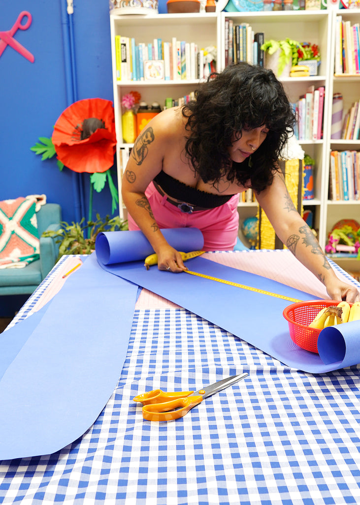 Kit, a craft-based designer, prepares a paper template in her colourful creative studio. 