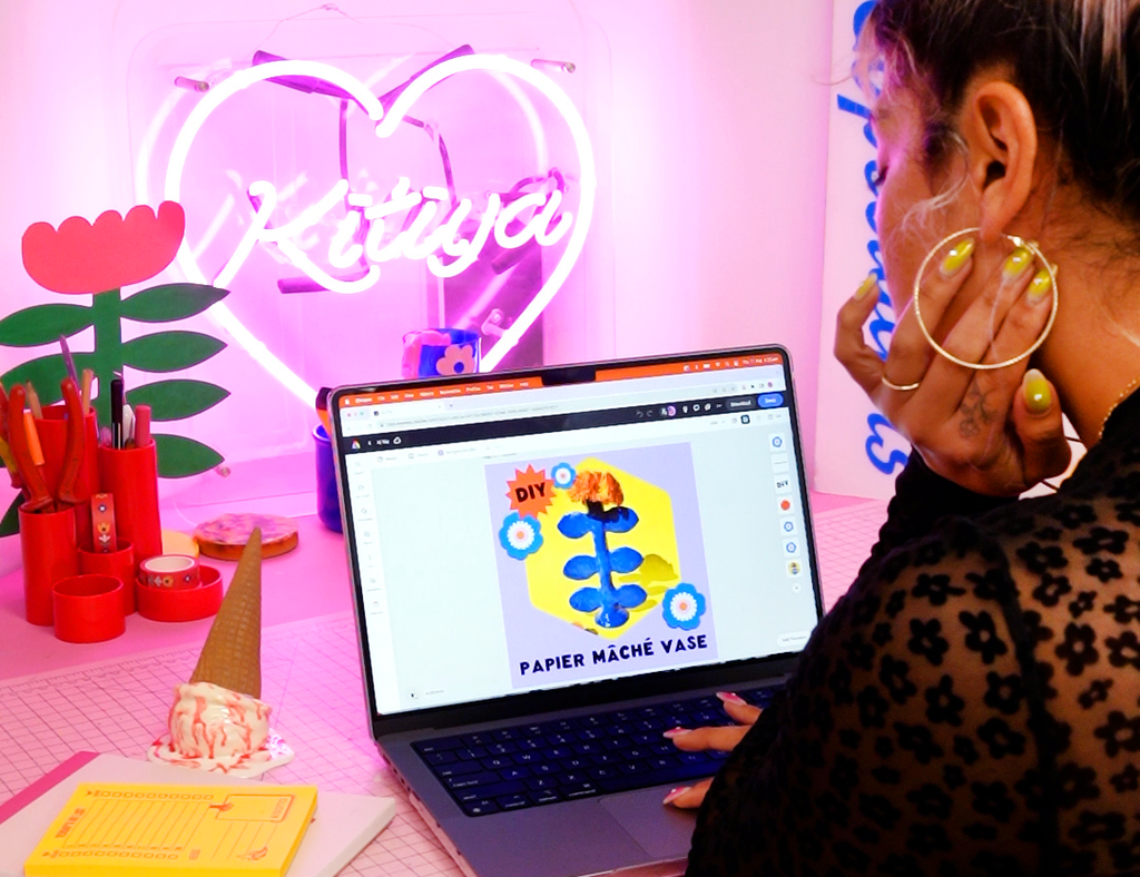 Kitiya, a craft-based designer, sits at a desk creating a digital design using Adobe Express.