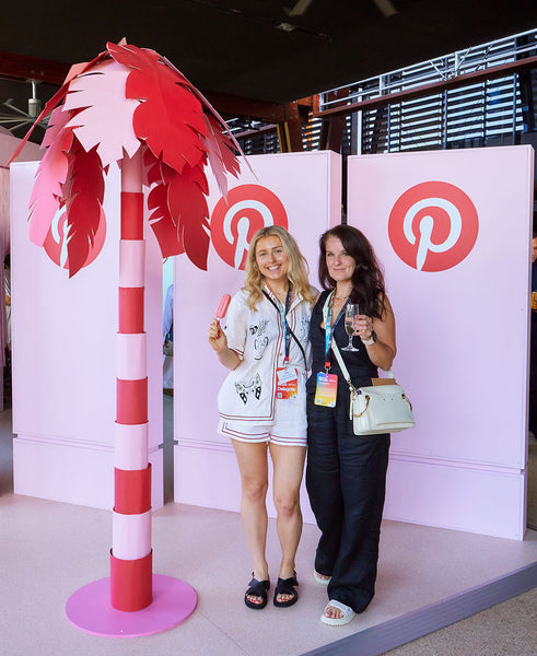 Conference attendees next to giant red paper palm tree prop at the Pinterest's Cannes In Cairns Conference