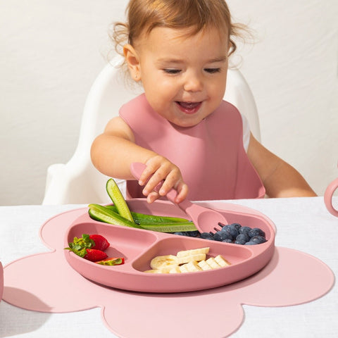 Happy child eating from silicone plate