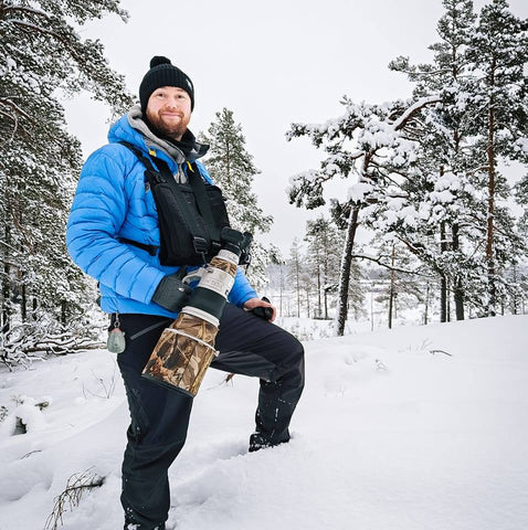 Luontokuvaaja Tuomas Heinonen lumisessa metsässä