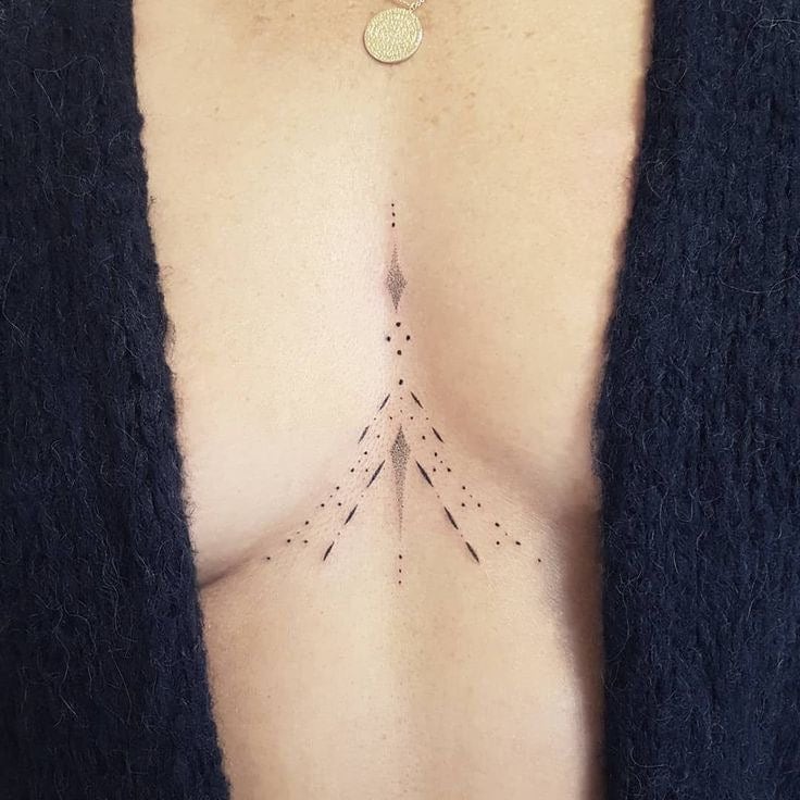 Minimalist black snake tattoo on the sternum