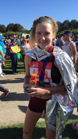 Ally with the marathon finisher flag around her body and a bottle of PWR lift