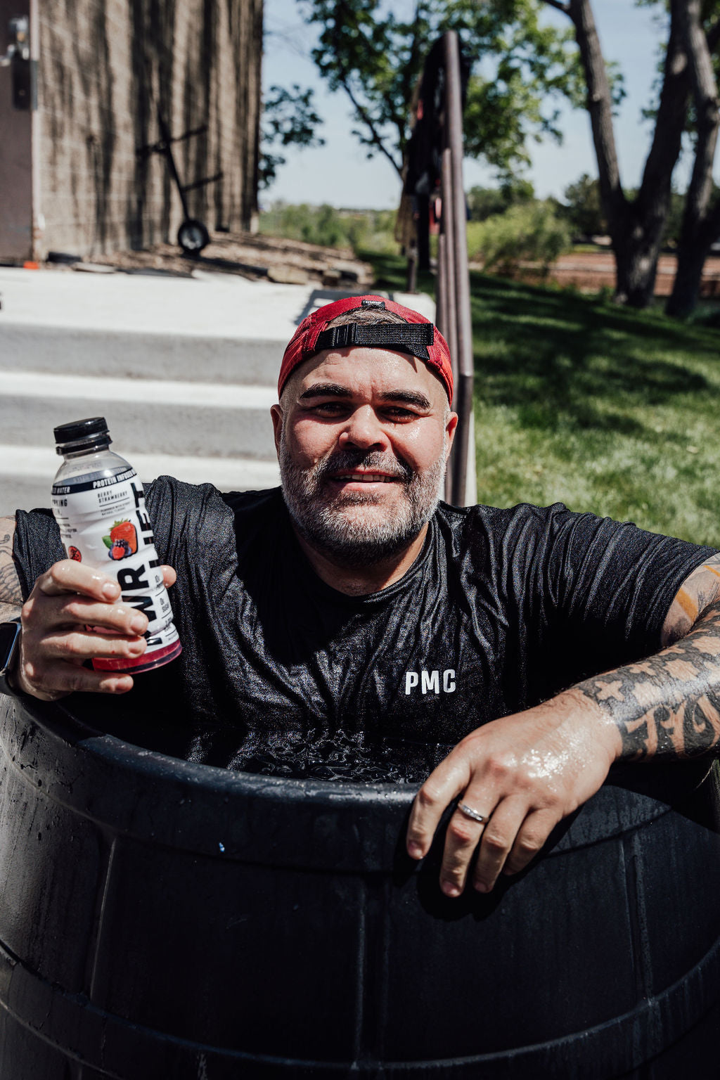 A man holding a PWR lift bottle smiling at the camera