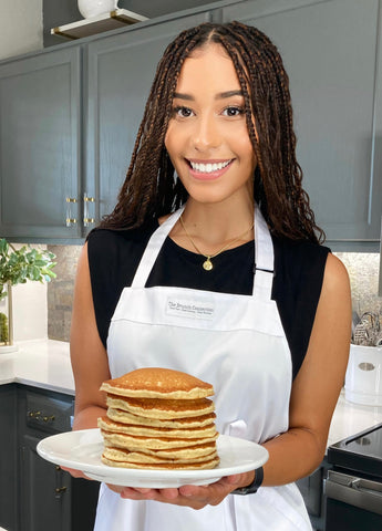 Brunch Connection team member holding a plate of our pancakes