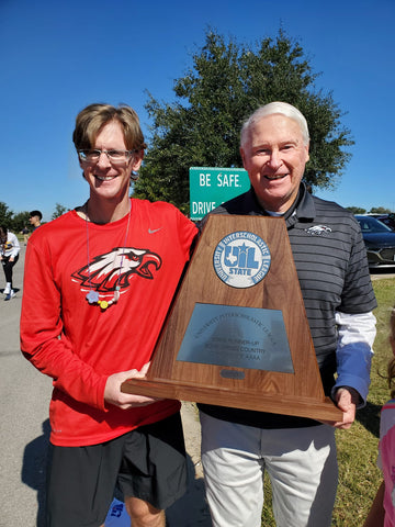 Coach Will Carter and Coach Jerry Carter holding state cross country meet trophy