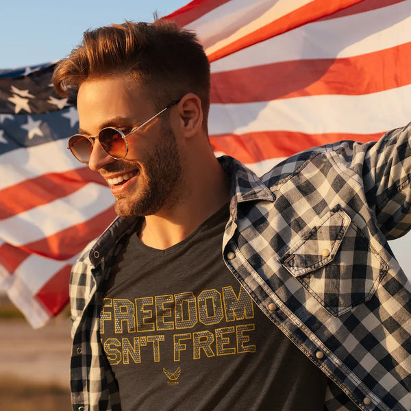 Young man wearing Freedom Isn't Free t-shirt holding American Flag