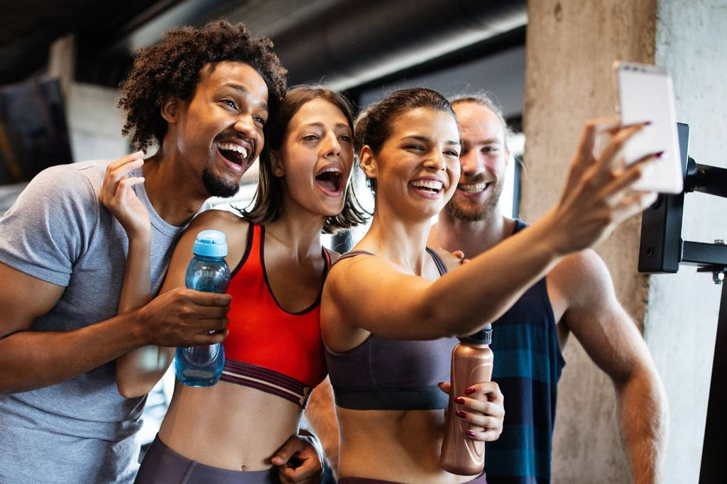 Quatros amigos na academia tirando uma selfie