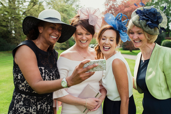 women taking photos at a wedding